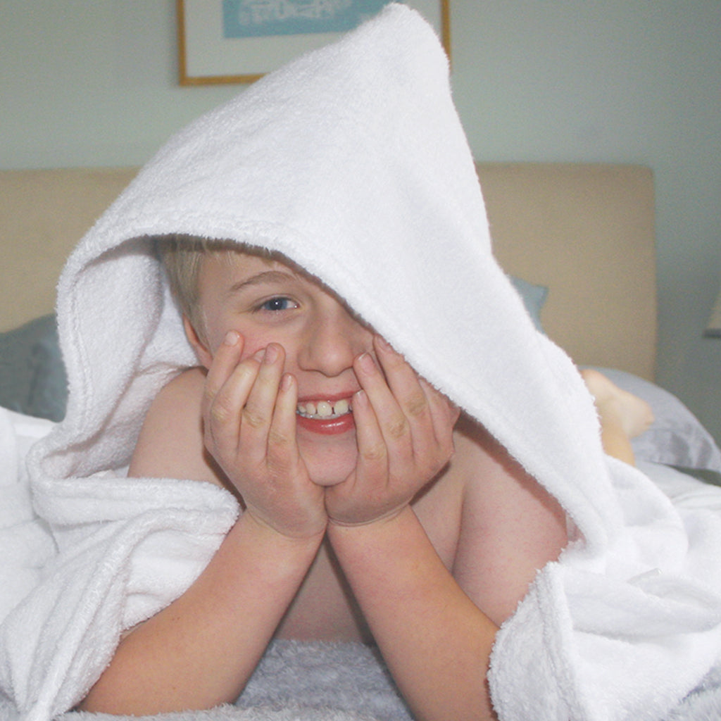 Cheeky boy wearing a Simply for Kids hooded towel
