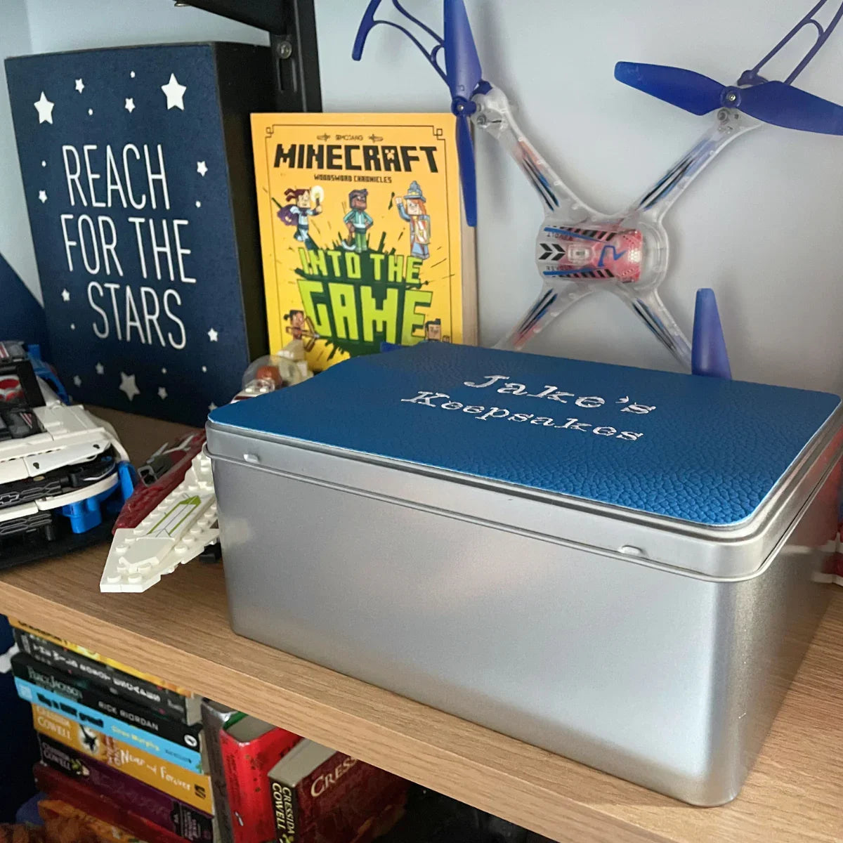 Jake's keepsakes tin on a shelf with toys, books, and Reach for the Stars sign