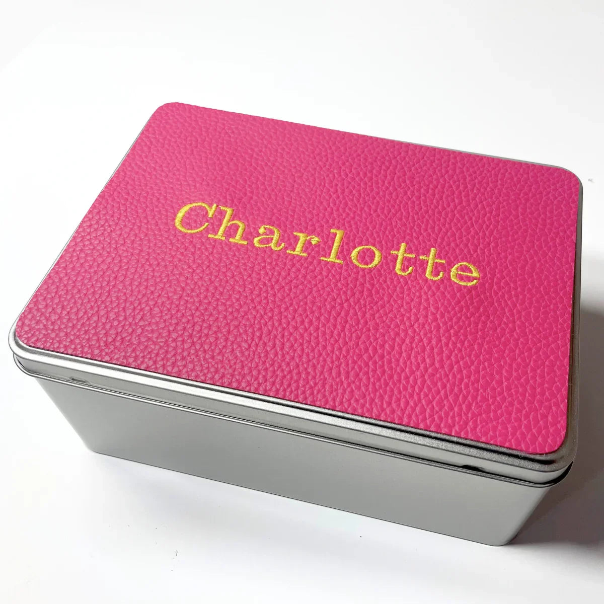 Personalized tin box with pink textured lid and 'Charlotte' in yellow text