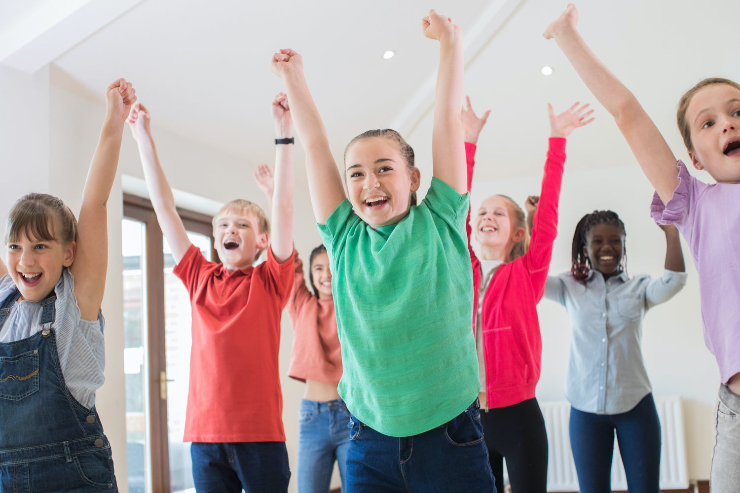 Happy kids with arms stretching to the air who would love a hooded towel by Simply for Kids